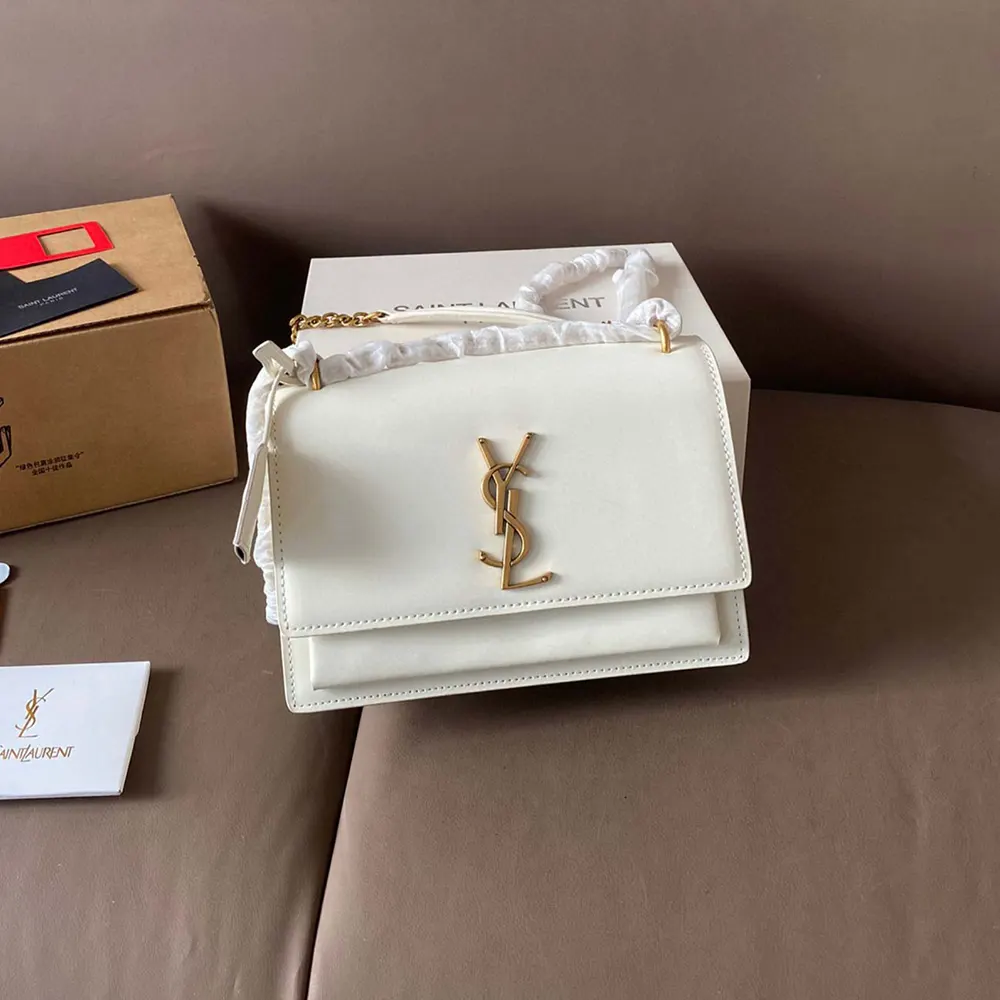 Close-up of silver YSL logo hardware on white leather bag