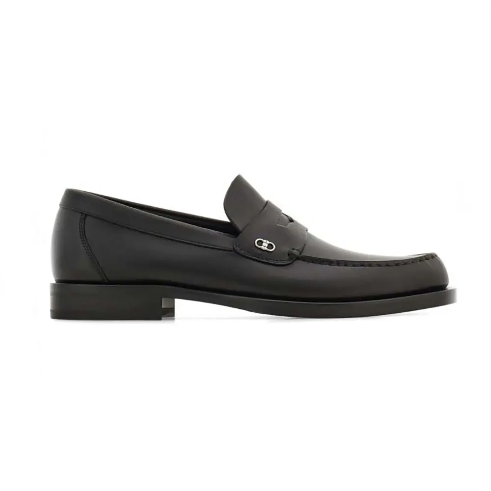Close-up of black leather and Gancini ornament on Salvatore Ferragamo Men Penny loafer