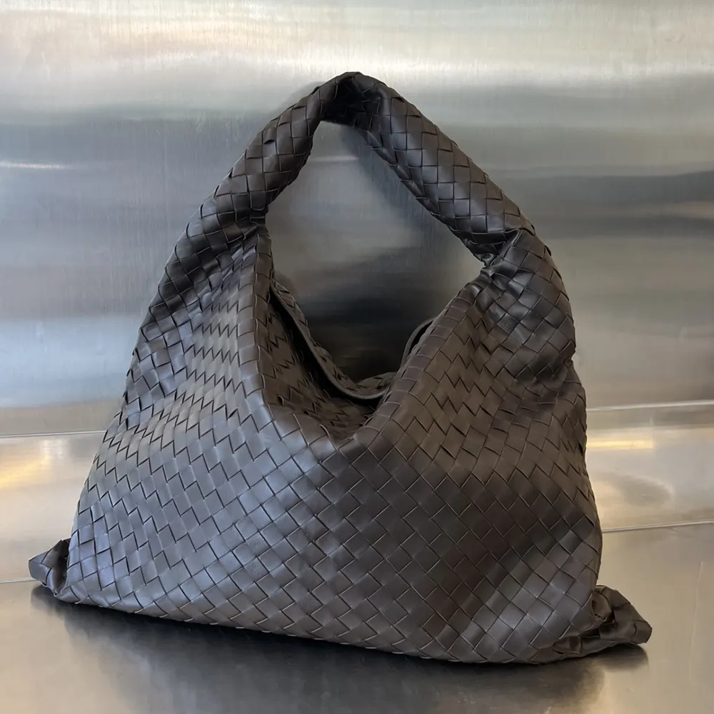 Side angle showing gold hardware and flap closure of Bottega Veneta shoulder bag