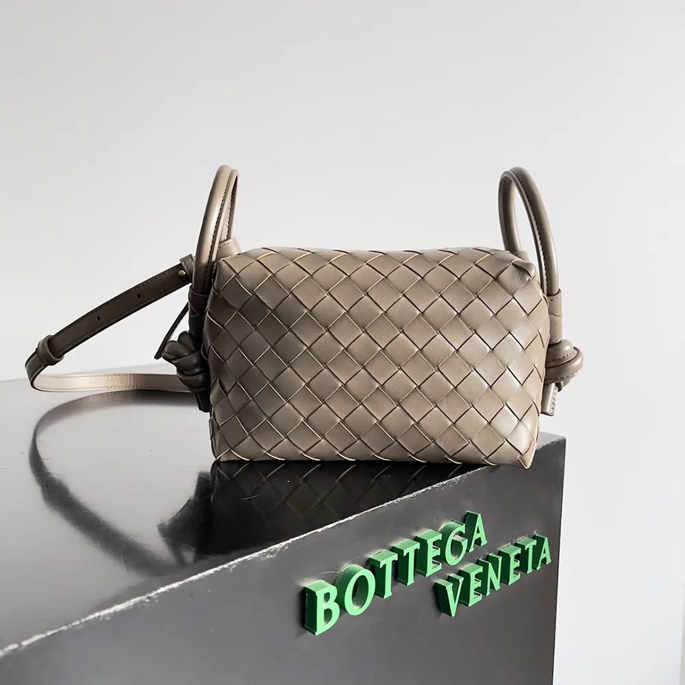 Close-up of woven Intrecciato leather and gold hardware detail on luxury bag