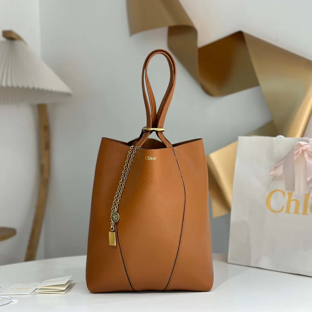 Side angle showcasing the brown grained leather texture on Chloe Women Chloé Spin Tote Bag
