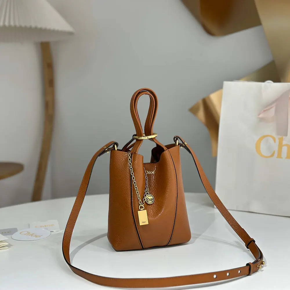 Close-up on gold-tone spinning closure of Chloe Women Small Chloé Spin Tote Bag