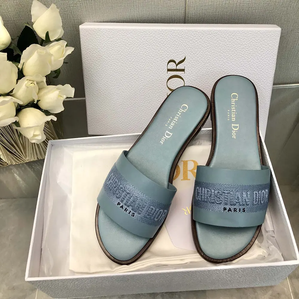Close-up of embroidered cotton and Dior hardware on slide sandal