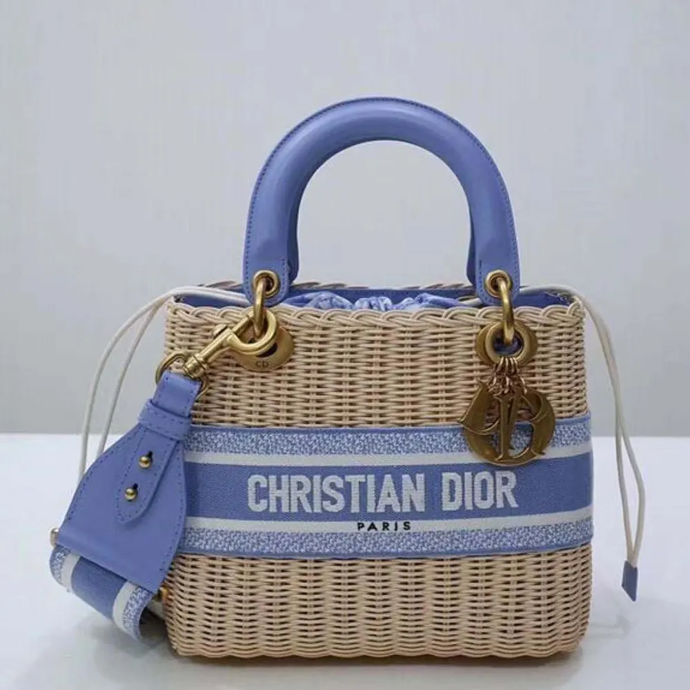 Close-up on silver-tone hardware and Dior charm of Lady Dior bag in natural wicker