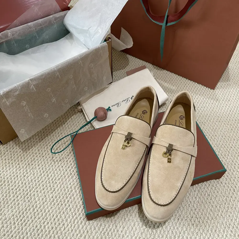 Close-up detail of charm hardware on Loro Piana loafer beige