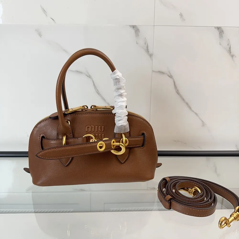 Close-up of gold-tone closure on Miu Miu Women Aventure Leather Bag