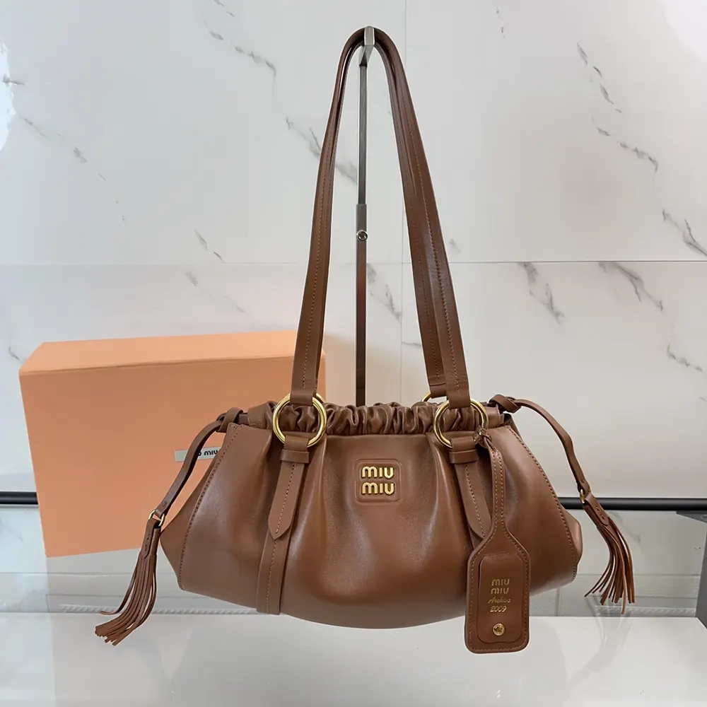 Side angle of Miu Miu Women Joie Nappa Leather Bag-Brown highlighting silhouette