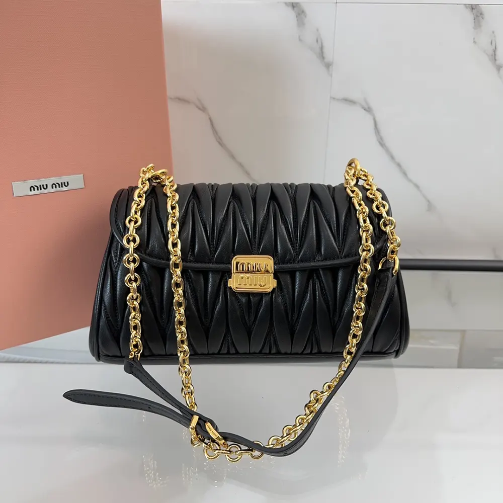 Close-up on matelassé quilted pattern of Miu Miu black shoulder bag
