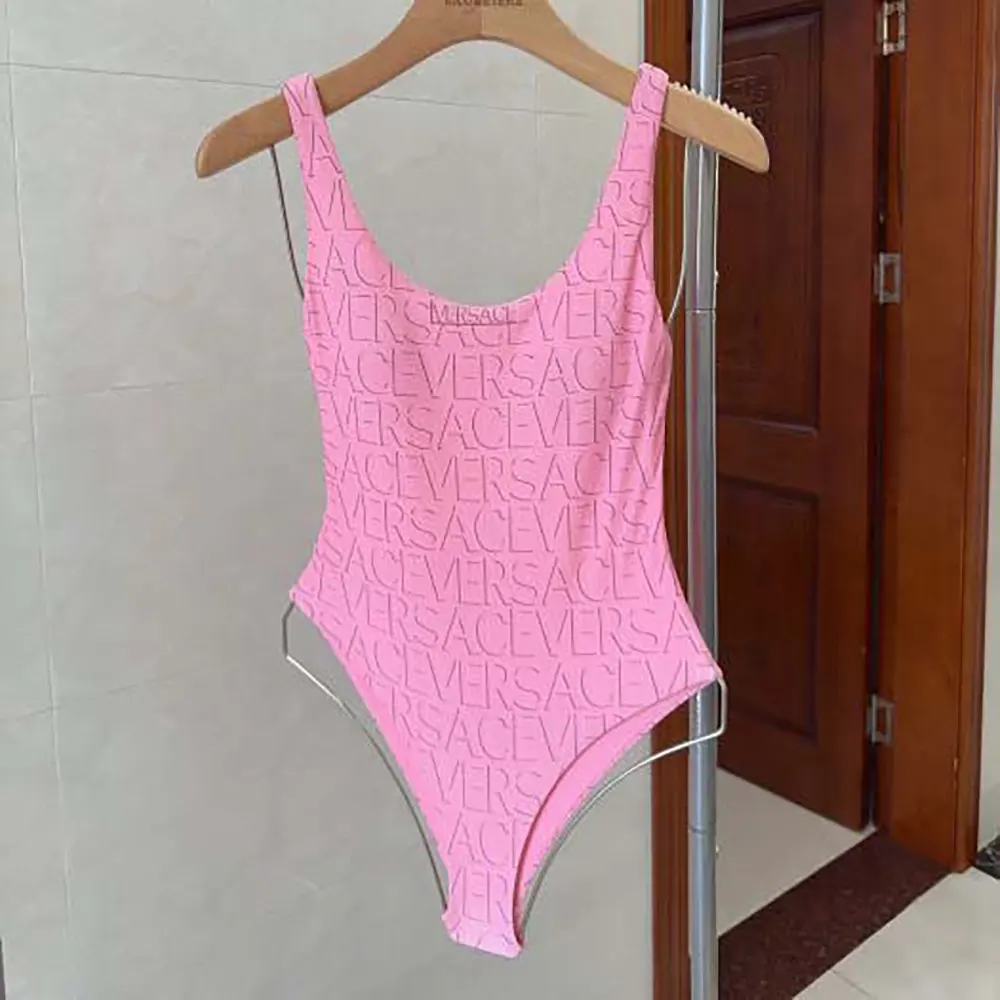 Close-up detail of gold Medusa emblem on Versace Women Allover One-piece Swimsuit-Pink