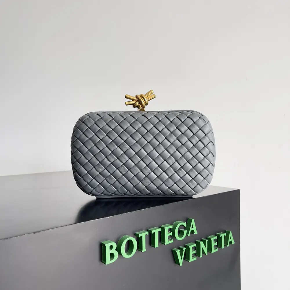 Close-up of gold-tone knot hardware on Bottega Veneta Grey clutch
