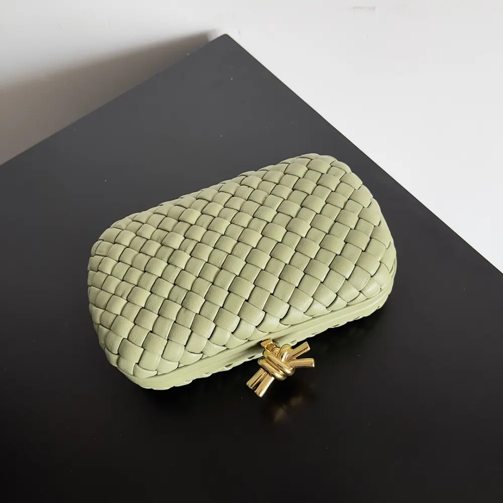 Side angle showing compact silhouette of Bottega Veneta Women Knot Minaudière Clutch