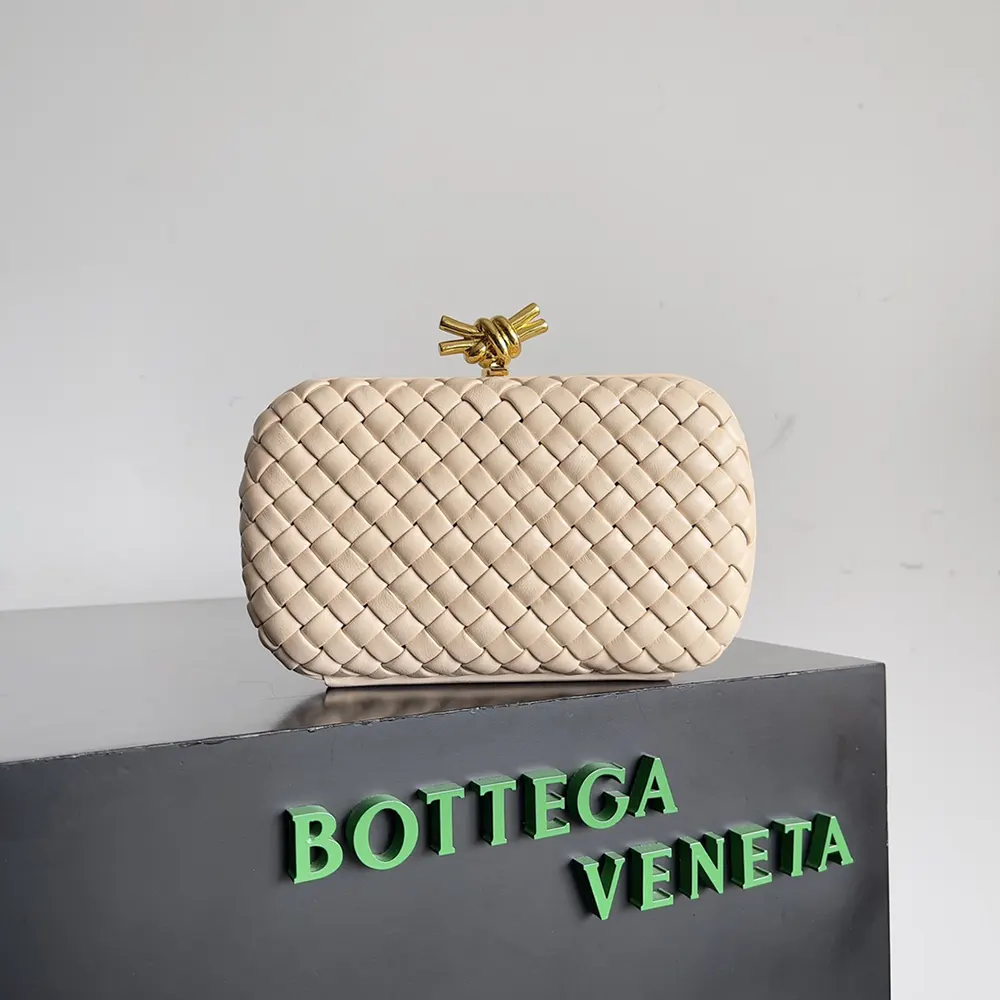 Close-up of gold knot clasp on Bottega Veneta pink leather clutch
