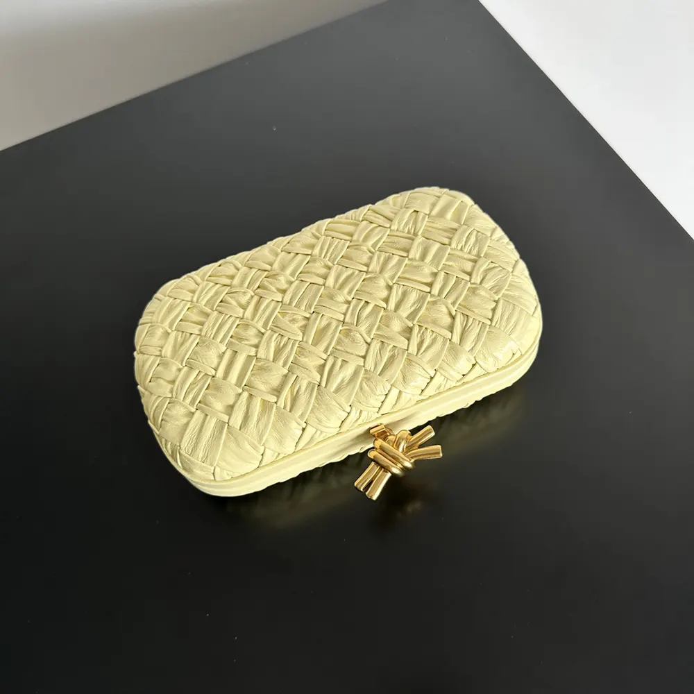 Side angle showing compact silhouette of Bottega Veneta Women Knot Minaudière Clutch