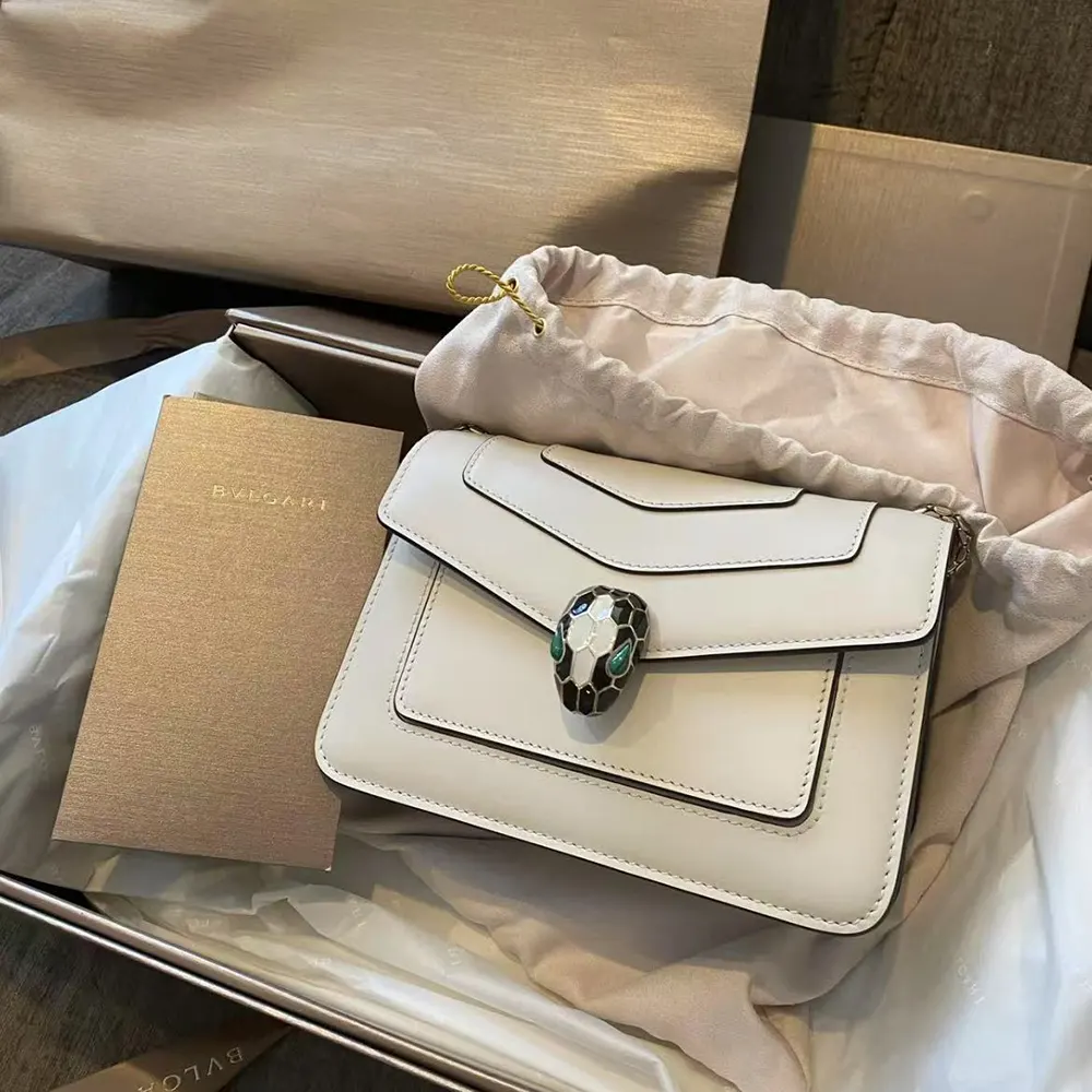 Close-up of gold Serpenti coil hardware on white shoulder bag