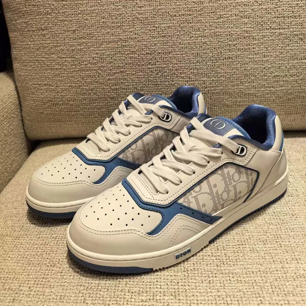 Close-up on blue leather accents and Dior embossed branding on low-top sneaker