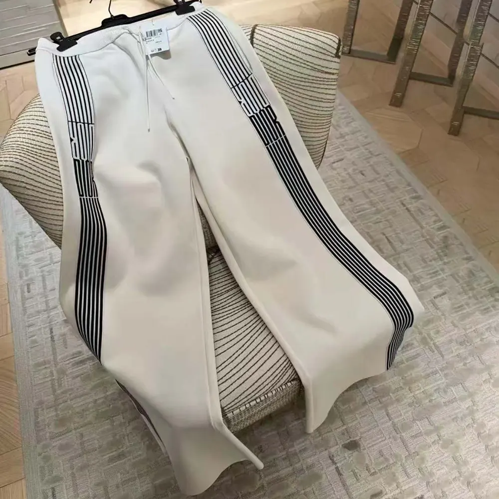 Close-up of black Dior graphique motif on white flared pants