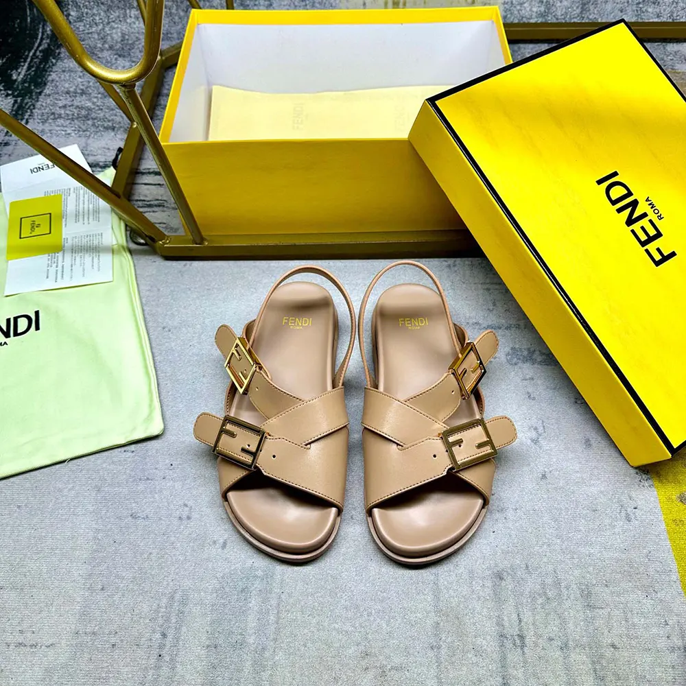 Close-up of gold-tone Fendi hardware on beige leather slides