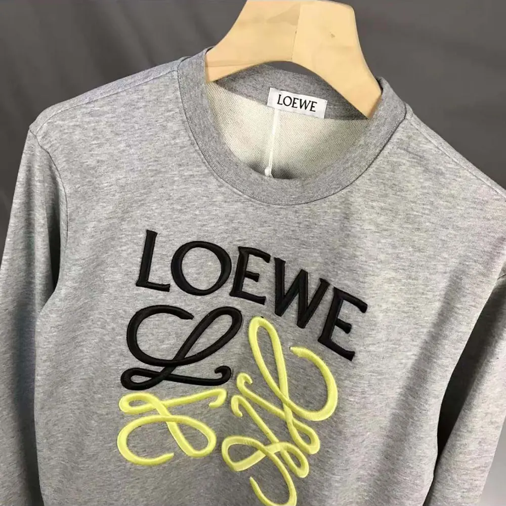 Close-up of yellow Anagram embroidery on Loewe sweatshirt cotton fabric