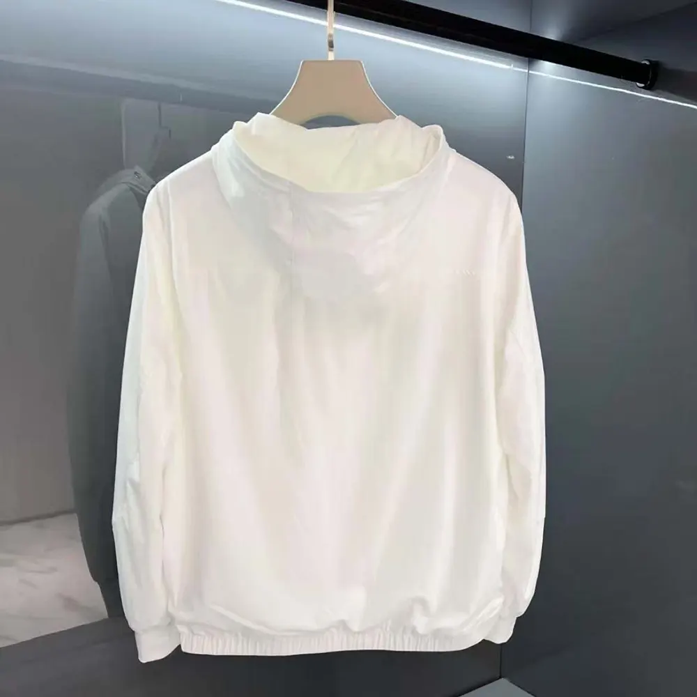 Close-up of Prada logo plaque on white windbreaker chest detail