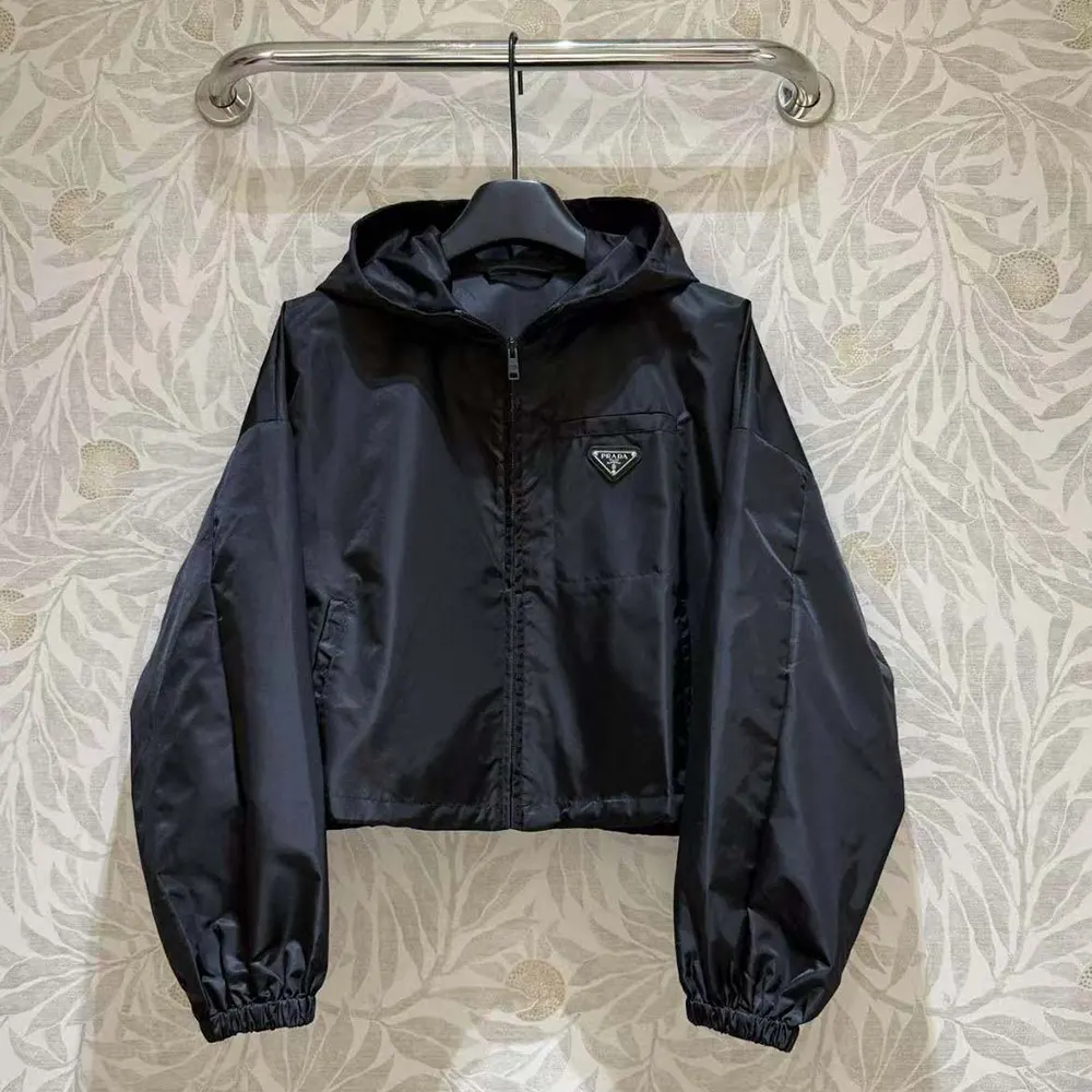 Close-up of Prada logo hardware on black Re-Nylon cropped jacket