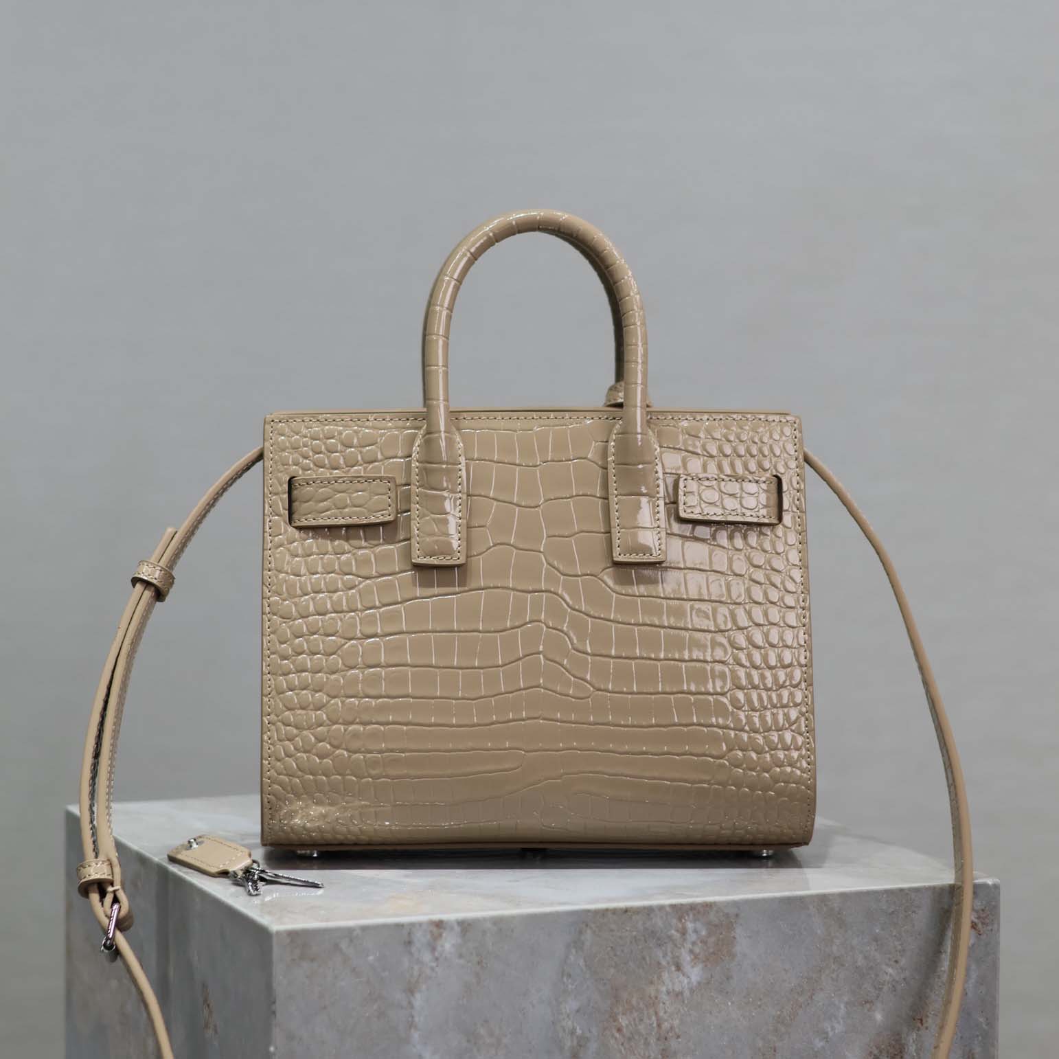 Close-up of gold YSL hardware on Nano-Sandy crocodile embossed bag