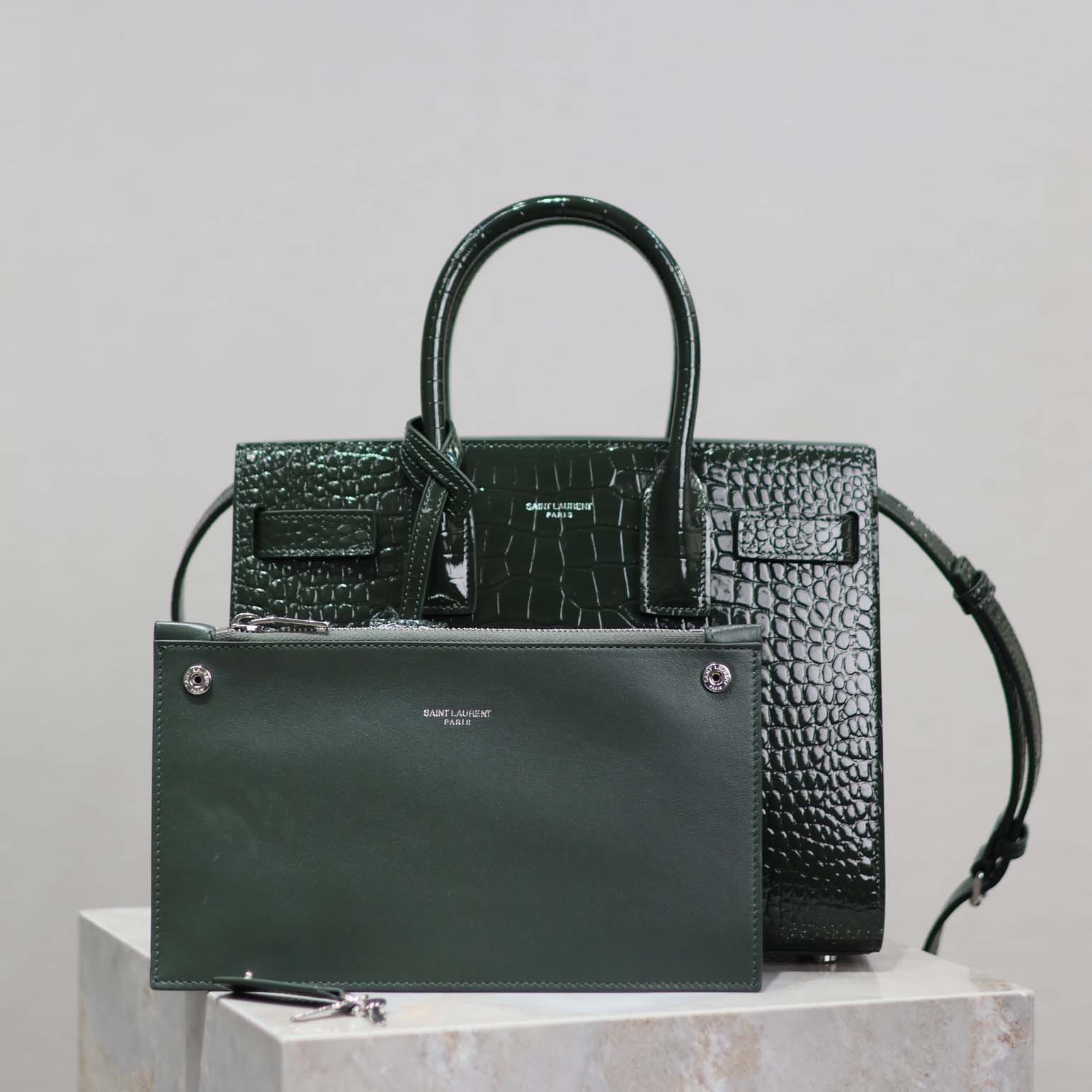 Close-up of gold YSL hardware on dark green embossed crocodile leather Sac De Jour