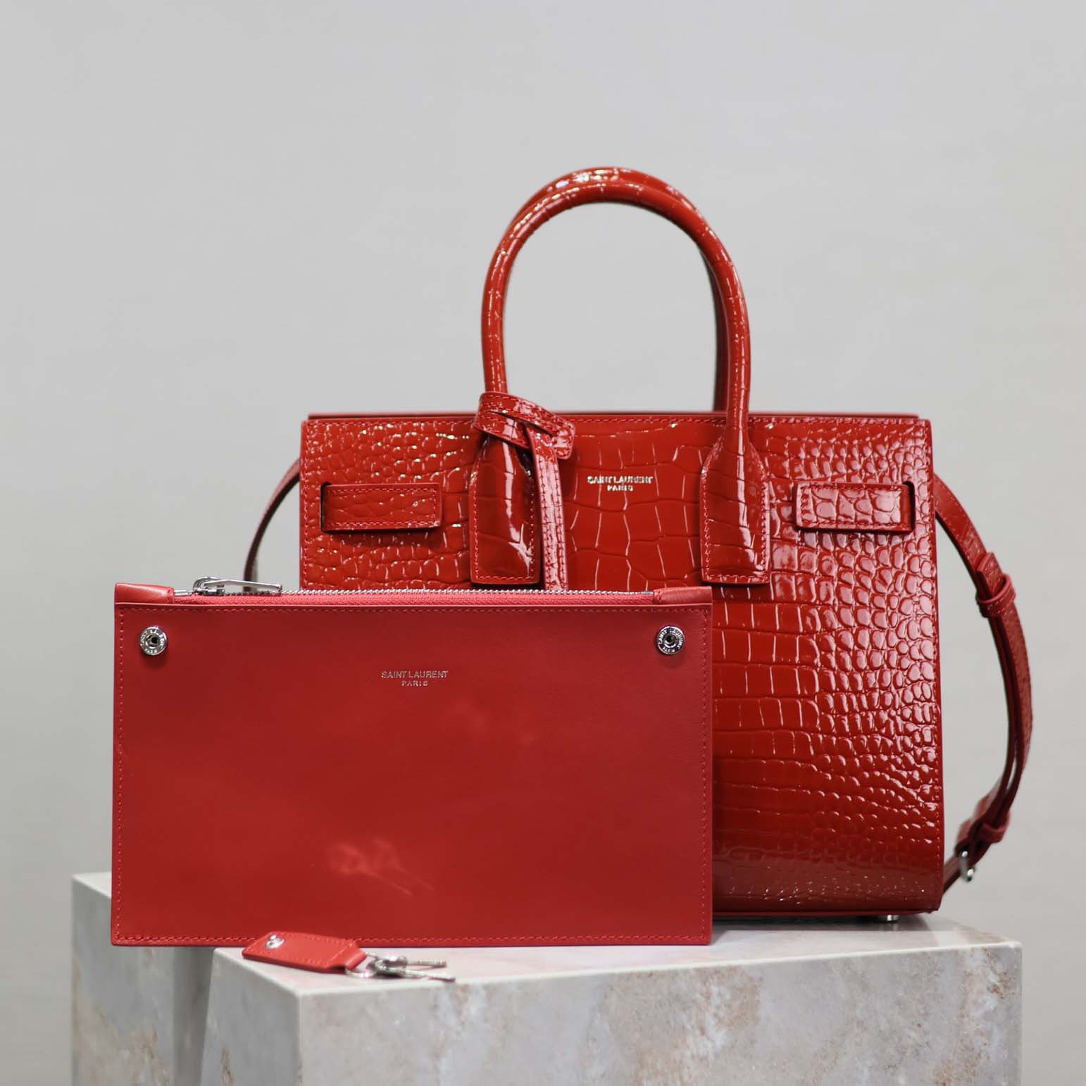 Close-up of gold YSL hardware on baby-red embossed crocodile Sac De Jour