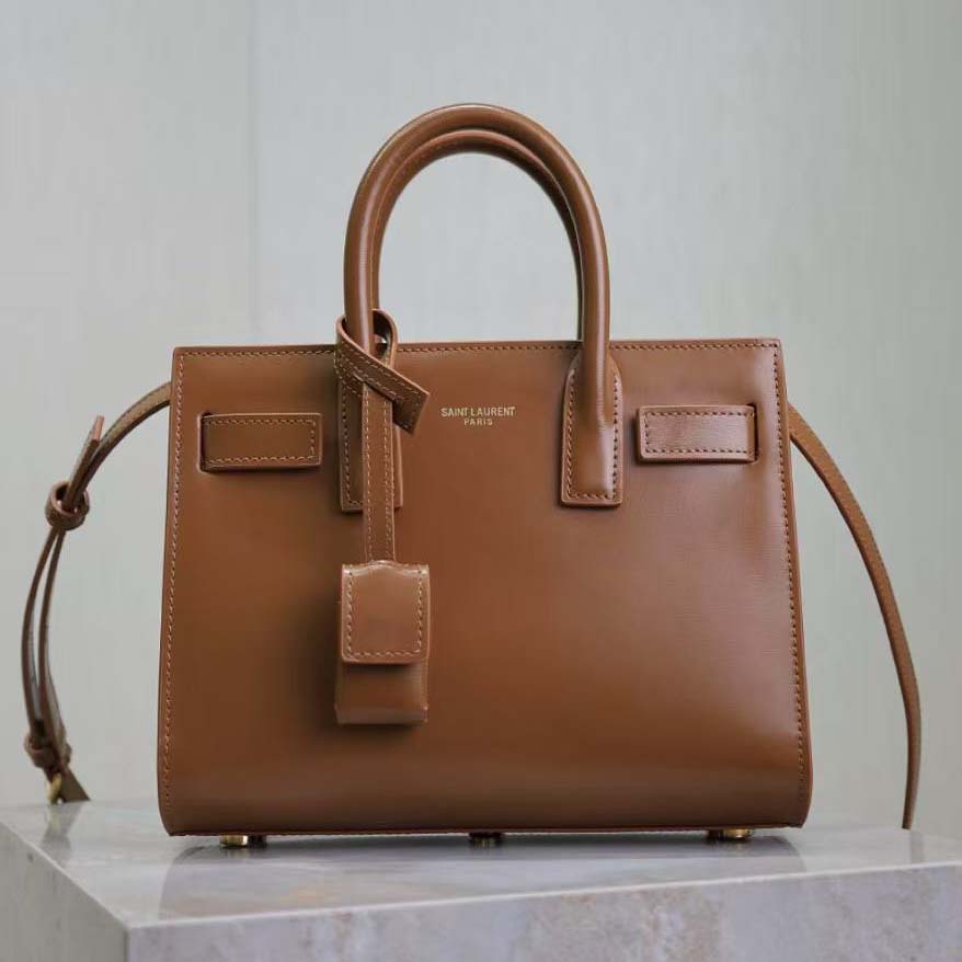 Close-up of gold YSL monogram hardware on leather bag