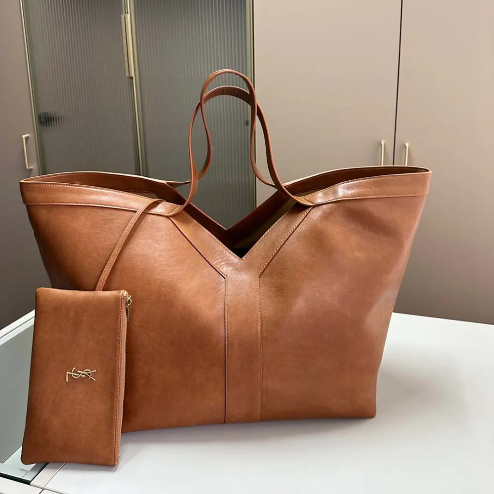 Close-up of brown leather texture and gold YSL hardware on tote