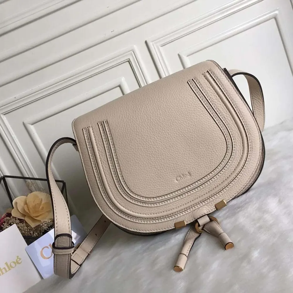 Side angle showcasing shape of Chloe Women Marcie Small Saddle Bag-Sandy