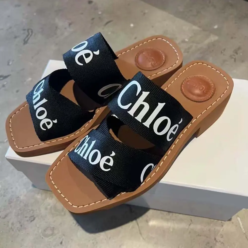 Close-up of black leather and gold logo on Chloe Women Woody Heeled Mule-Black