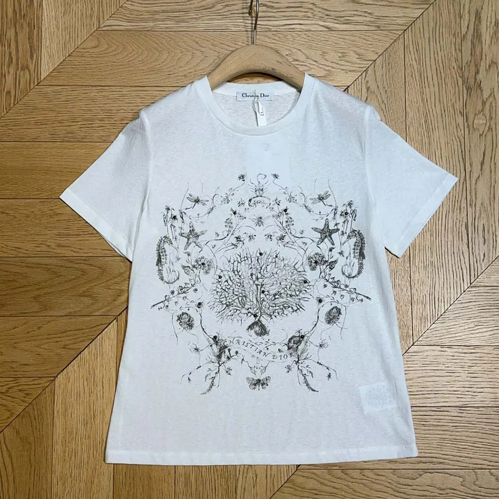 Close-up detail of black Dior Cabinet de Curiosités motif on white T-shirt
