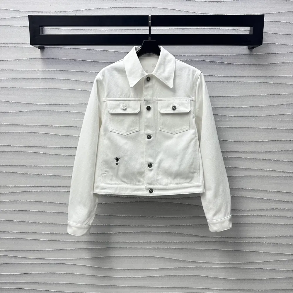 Close-up on gold-tone Dior Astral motif on white cotton denim jacket