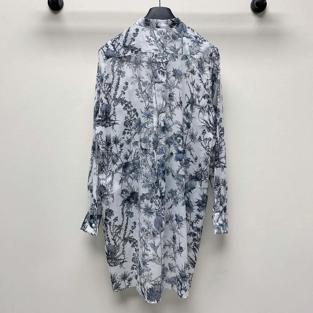 Close-up detail of blue Dior Chardons print on white cotton muslin blouse