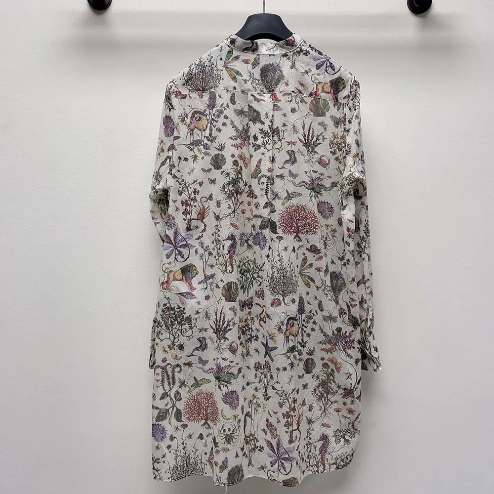Detail of signature Dior buttons on cuff of white cotton muslin blouse