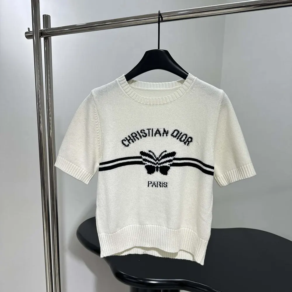 Close-up of black Christian Dior Papillon motif on white cashmere sweater