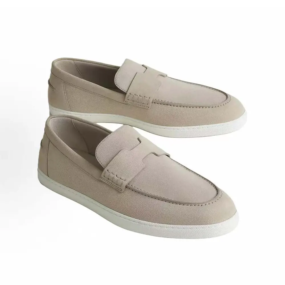 Close-up of beige lambskin leather and embossed Hermes logo on loafer