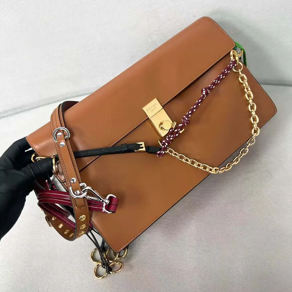 Side angle showing textured brown leather and silhouette of Prada shoulder bag