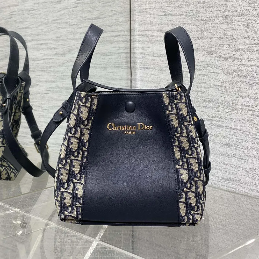 Close-up detail of smooth calfskin and gold hardware on Dior bucket bag