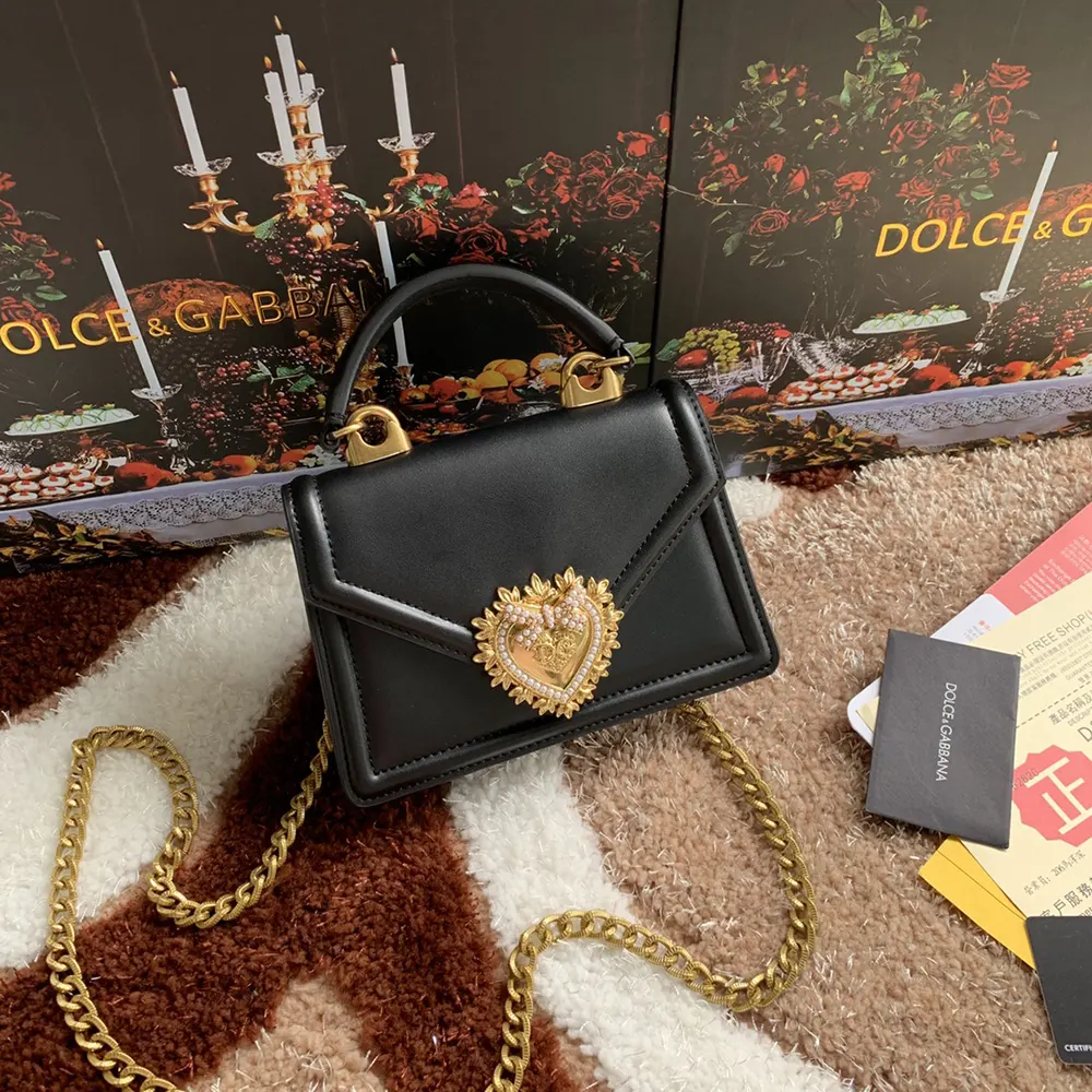 Side angle showing smooth black calfskin and adjustable strap of D&G Devotion Bag