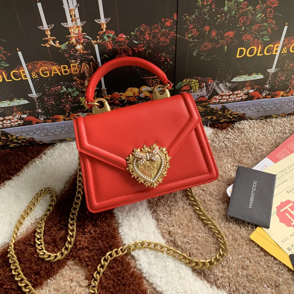 Close-up of gold logo clasp on Dolce Gabbana D&G Devotion Bag in red