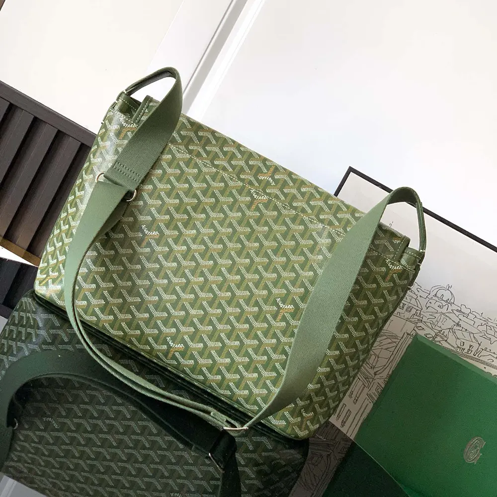 Side angle showing leather strap and brass hardware of Goyard messenger bag