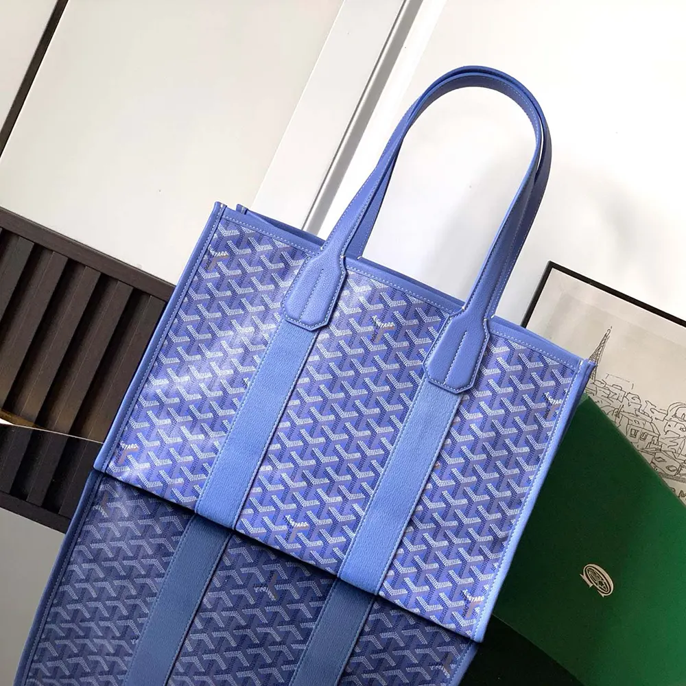 Close-up detail of blue coated canvas and matte black hardware on tote