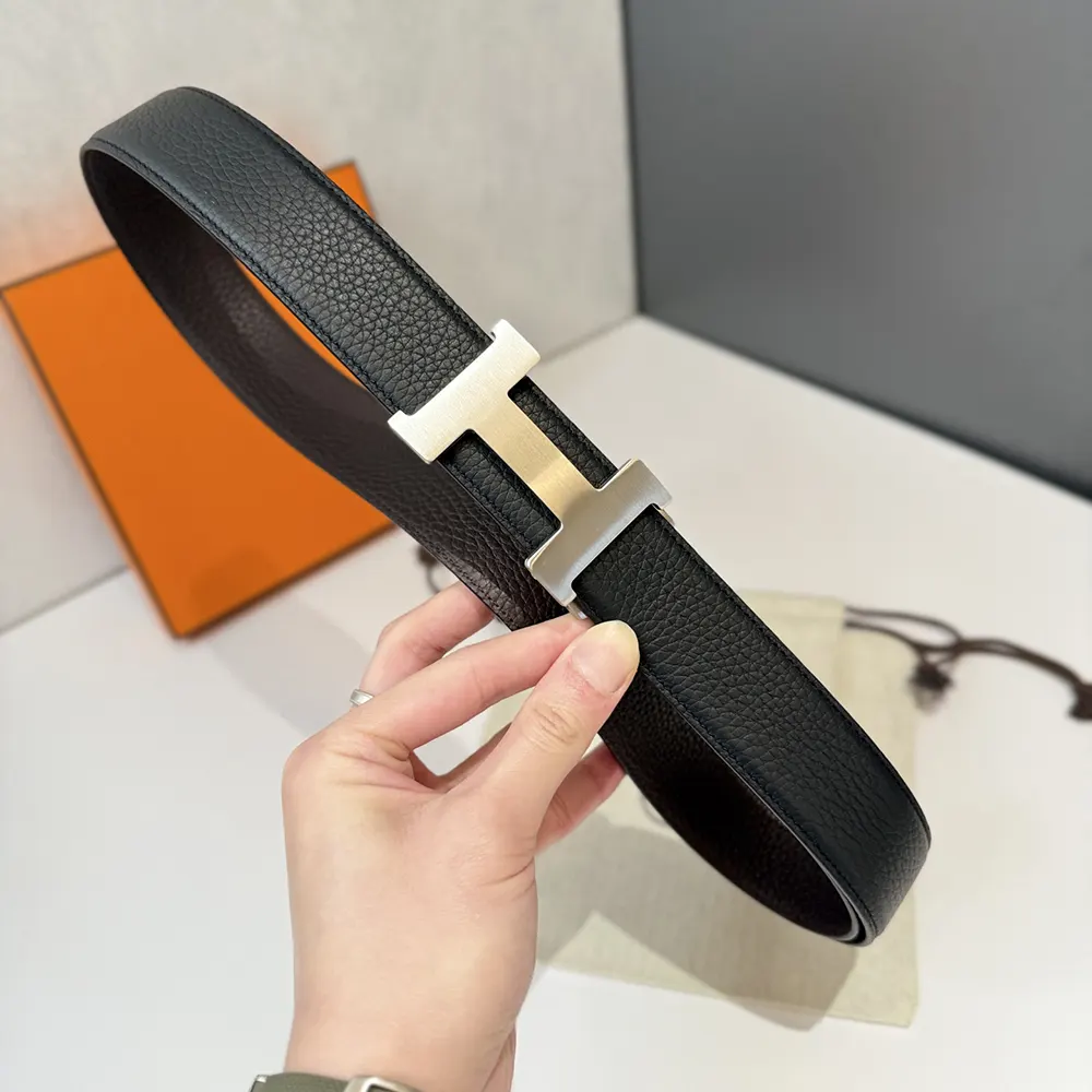 Close-up of polished silver H buckle on Hermes unisex belt