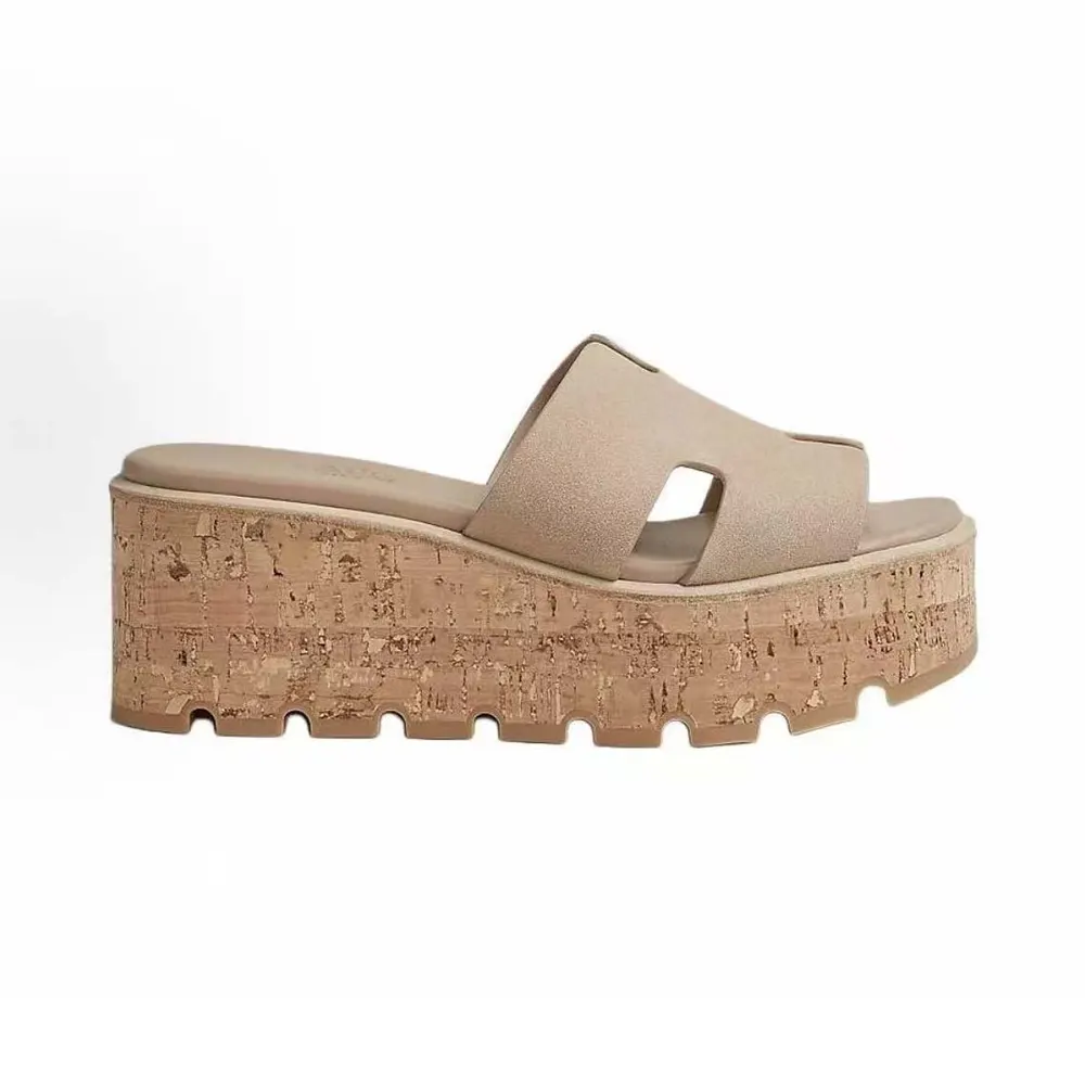 Close-up of silver-tone Hermes ‘H’ hardware on natural sandal