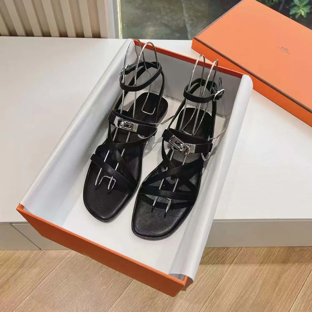 Close-up of black calfskin and signature Hermes 'H' cutout on June Sandal