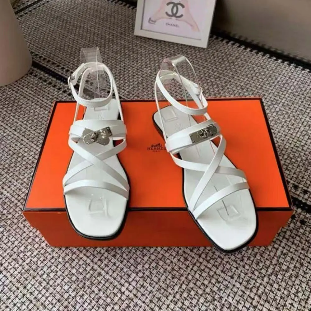 Close-up of white calfskin and Hermes ‘H’ detail on June Sandal