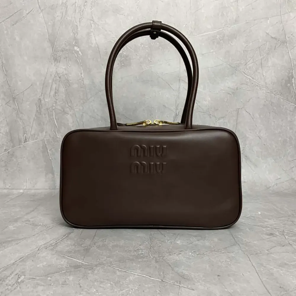 Close-up of gold-tone hardware on Miu Miu Women Beau Leather Top-handle Bag-Briarwood