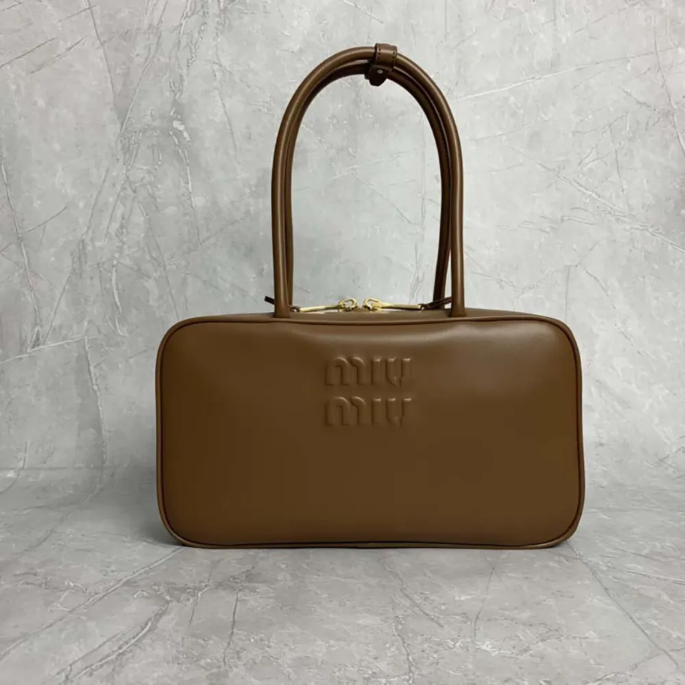 Close-up of gold-tone hardware on Miu Miu Women Beau Leather Top-handle Bag-Brown