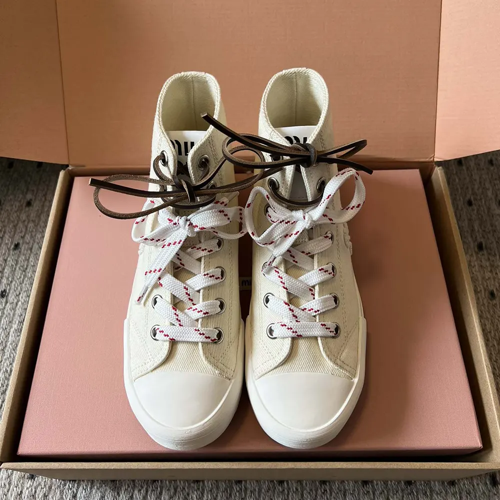 Close-up detail of silver eyelets on Miu Miu Women Washed Denim High-top Sneakers